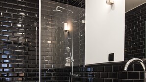 Une salle de bain moderne avec une douche à parois de verre, des toilettes blanches et un lavabo avec un miroir au-dessus.