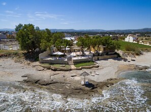 Une station balnéaire dotée d’une terrasse en pierre, de sièges extérieurs et offrant une vue sur la mer.