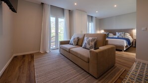 Un dormitorio moderno con sofá, cama y televisor.