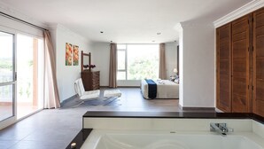 A modern bathroom with a large bathtub, a shower area, and a vanity with a mirror. - Large Villa near Ibiza Town Sleeps 20/22 (Ibiza)
