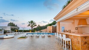 A pool area with lounge chairs and a bar. - Large Villa near Ibiza Town Sleeps 20/22 (Ibiza)