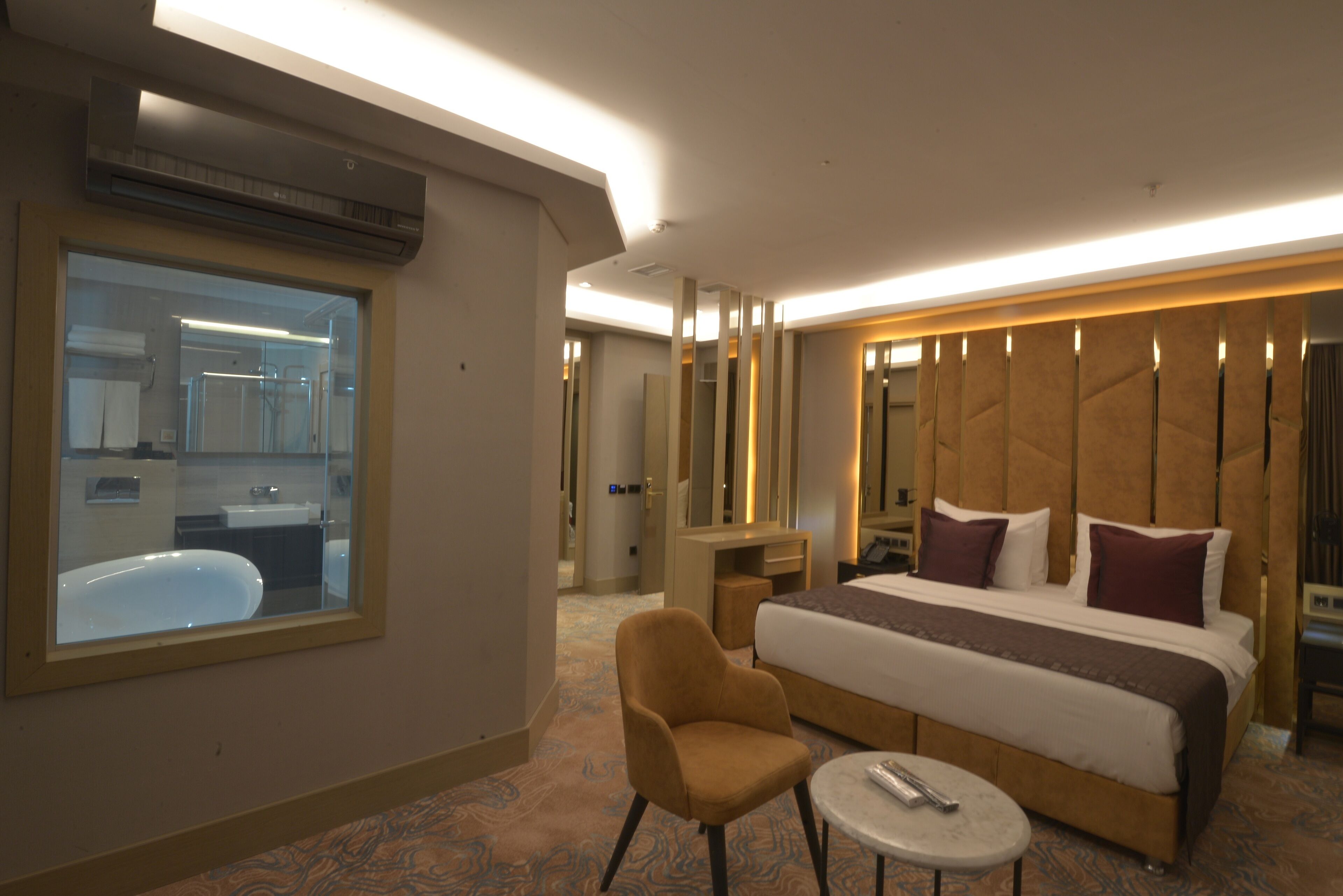 Ein Hotelzimmer mit einem großen Bett, einer Sitzecke, einem kleinen Tisch und einem Fenster.