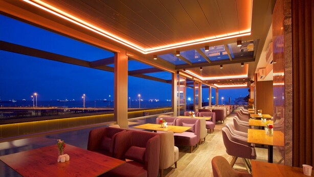 A modern restaurant with a view of the sea at dusk. - Best Western Premier Ottoperla Hotel (Istanbul)