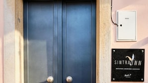 A double door with a metal handle, a plaque with the name "Sintra Inn" on the wall, and a small electrical box to the right. - Sintra Bliss A Part (Sintra)