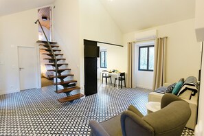 A spacious living area with a black and white patterned floor, a staircase, a dining area, and a sofa with patterned cushions. - Sintra Bliss A Part (Sintra)
