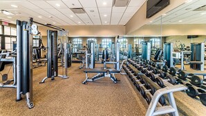 A gym with various exercise equipment, including weight machines and dumbbells. - Ev7883ha - Storey Lake Resort - 2 Bed 2 Baths Townhouse (Kissimmee)