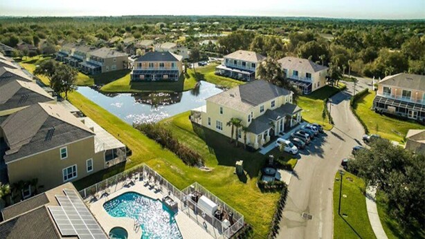 A residential area with houses, a swimming pool, and a road.