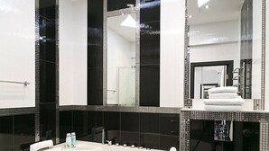 Ein modernes Badezimmer mit einer freistehenden Badewanne, einer Toilette und einem großen Spiegel.