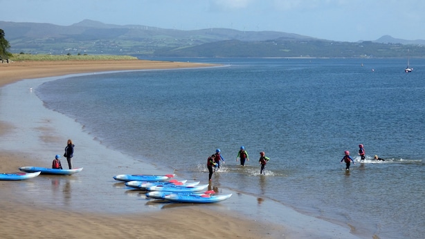 A beach with kayaks lined up and people preparing to paddle. - Rathmullan Holiday Homes (Rathmullan)