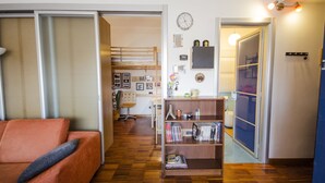 Ein Wohnzimmer mit einer Couch, einem Bücherregal und Holzboden.