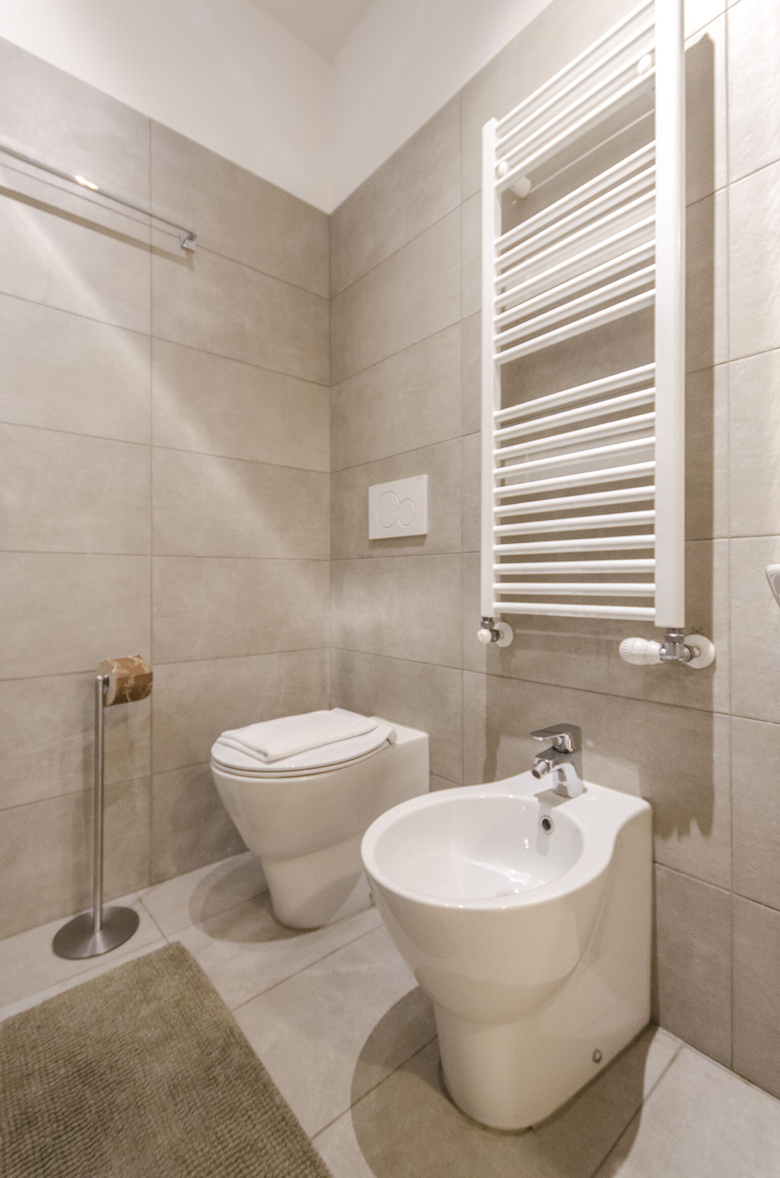 Ein modernes Badezimmer mit einem Bidet, einer Toilette und einem Waschbecken.