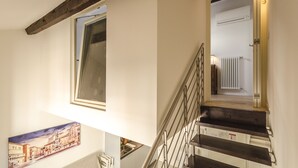 A staircase with metal railings and wooden steps leading to an upper floor. - Appartamento del Nettuno (Bologna)