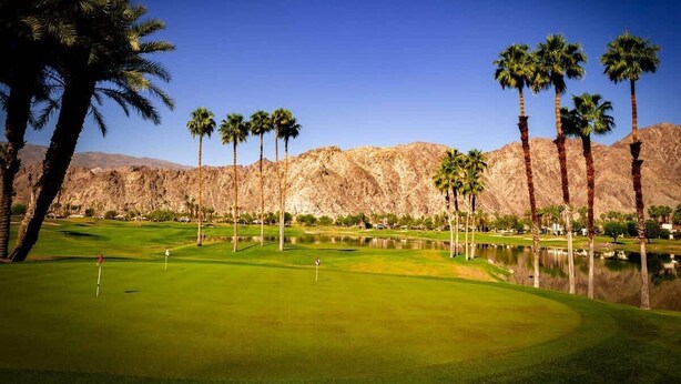 A golf course with palm trees and mountains in the background. - Hacienda Getaway Pool, Hot Tub, & Steps to trails. (La Quinta)