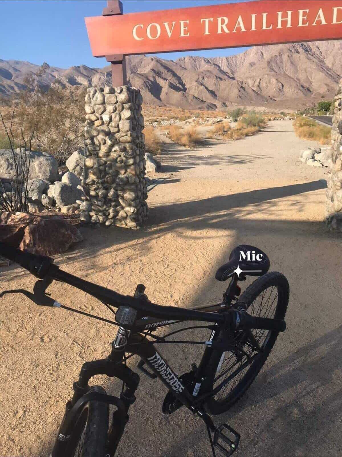 Una bicicleta estacionada frente a un letrero que dice "COVE TRAILHEAD".