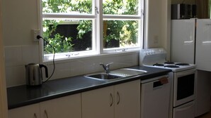 A compact kitchen with white cabinets, a sink, a kettle, and a stove. - Summer and winter retreat
3 bedrooms - 2 bathrooms (Hatepe)