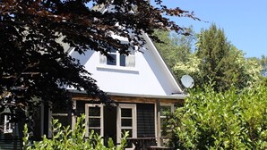 A white house with a gabled roof, surrounded by greenery. - Summer and winter retreat
3 bedrooms - 2 bathrooms (Hatepe)