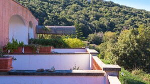 A building with a pink facade, arched windows, and a tiled roof. - Appartamento Il Mare in Cartolina (Portoferraio)