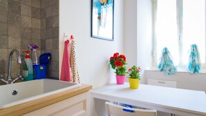 Un baño con bañera, lavamanos y ventana con cortinas.