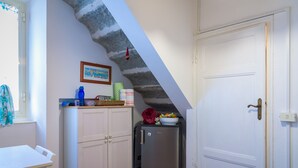 Una cocina con gabinetes blancos, un refrigerador de acero inoxidable y piso de baldosas.