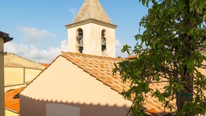 Un edificio con un campanile, una piccola finestra ad arco e una ringhiera bianca.