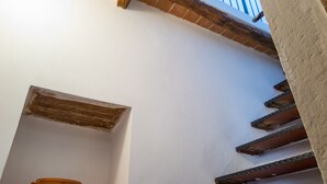 Una stretta scala con una piccola nicchia che contiene un vaso in terracotta.