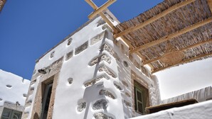 Un edificio blanco con detalles de piedra y techo de paja.
