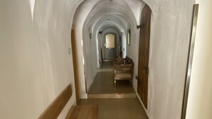 A hallway with a wooden bench, arched ceiling, and a door at the end. - Holiday suite "Chalet" in the "Ferienhaus Burgcafé" (Betzenstein)