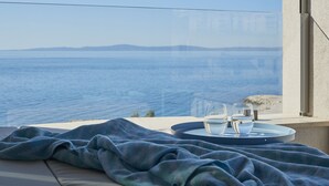 A balcony with a view of the sea, a table with a tray, and two glasses of water. - Eol Apartments Split (Split)