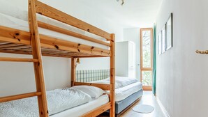 A bunk bed room with a wooden frame, a single bed, and a small table. - FeWo Schloß Ramspau - Forsthaus Ostwohnung (5-star DTV) (Ramspau)