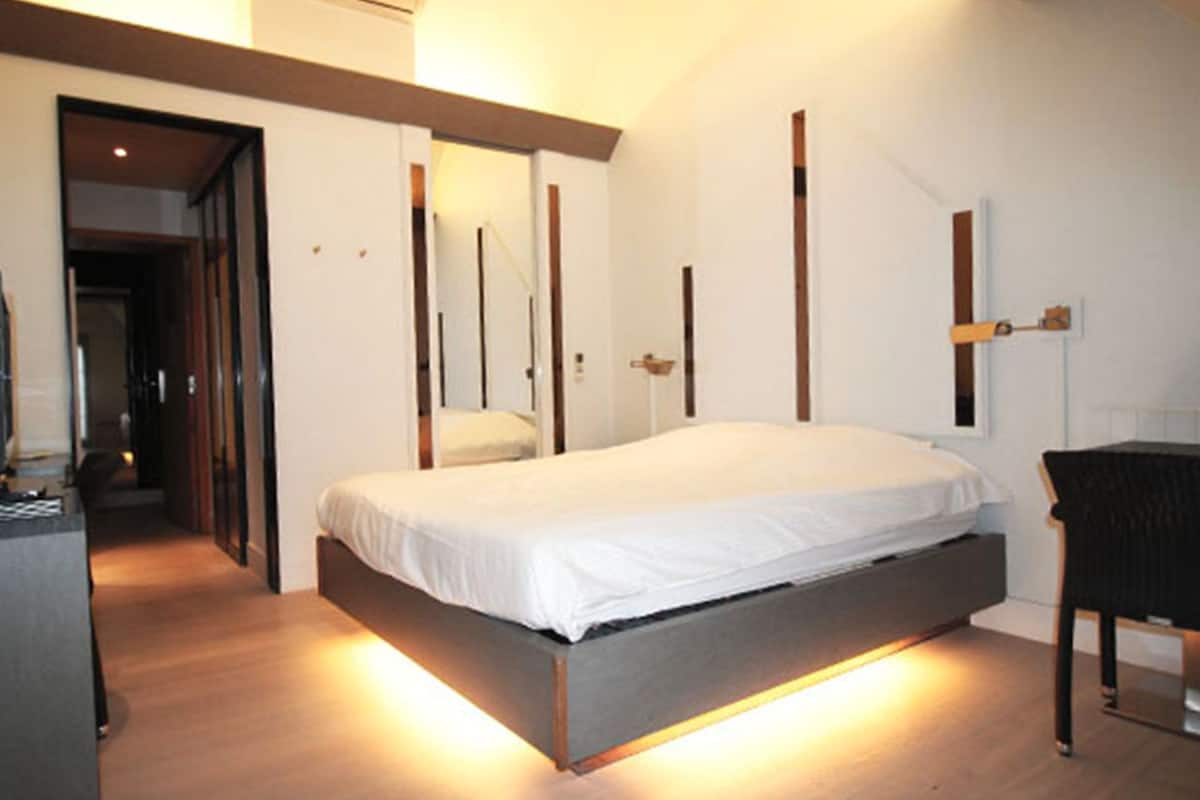 Un dormitorio moderno con una cama, un escritorio y una silla.