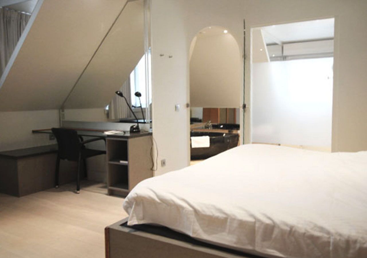 Une chambre à coucher avec un lit, un bureau et une chaise.