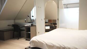 Une chambre à coucher avec un lit, un bureau et une chaise.