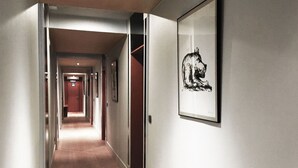 A hallway with a wooden floor, a framed picture on the wall, and doors leading to other rooms. - Hostellerie Klokhof (Kortrijk)