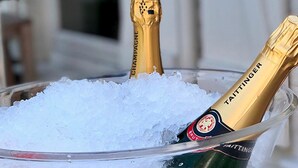 Una botella de champán en un cuenco de vidrio lleno de hielo.