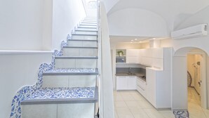 A modern kitchen with white cabinets, a built-in oven, and a sink. - Turchese choose to live an emotion (Ischia)