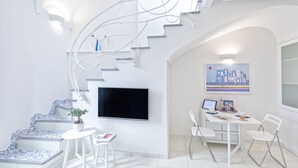 A modern interior with a staircase, a flat-screen TV, a dining area, and a painting on the wall. - Turchese choose to live an emotion (Ischia)