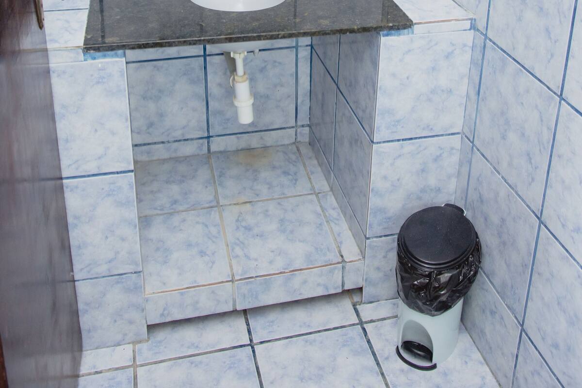 A bathroom with a sink, mirror, and tiled walls.