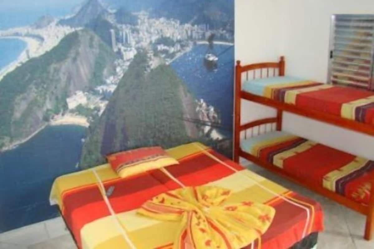 Habitación con literas y vista a una costa montañosa.