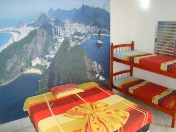 A room with bunk beds and a view of a mountainous coastline.