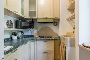 A kitchen with a microwave, stove, and cabinets.