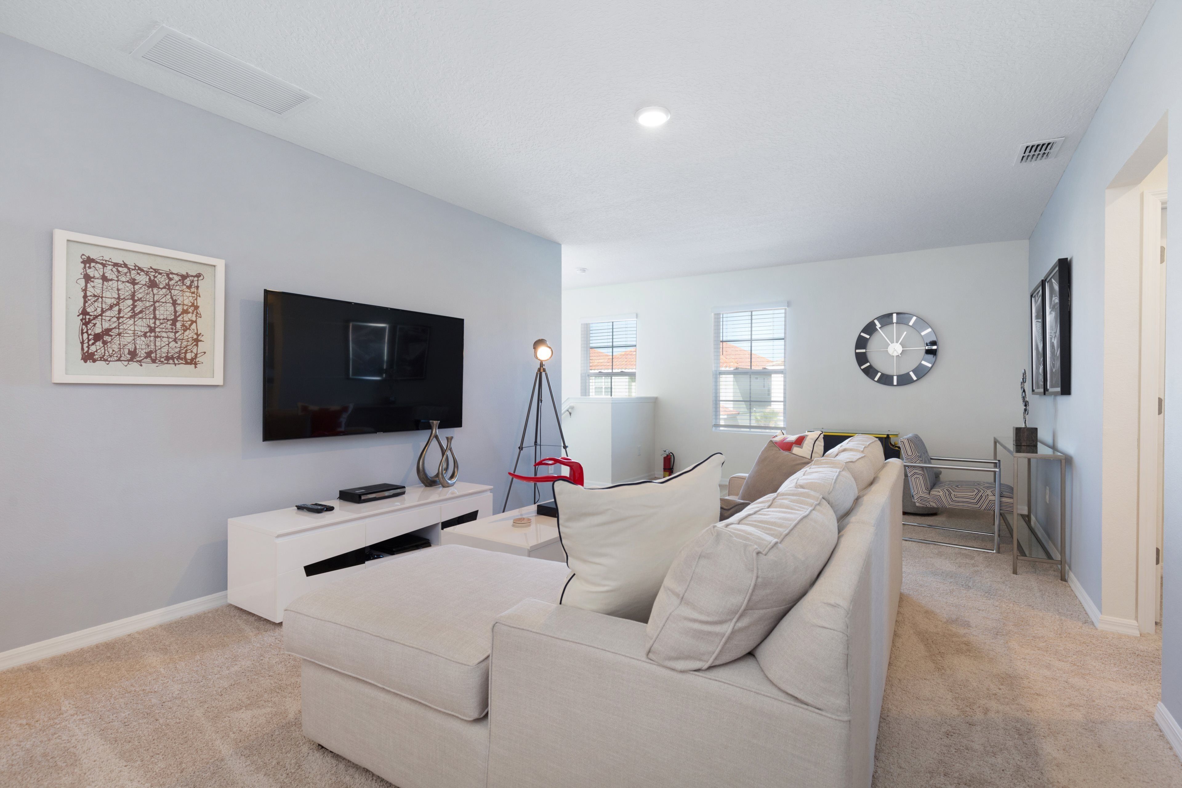 A modern living room with a flat-screen TV, a sofa, a coffee table, and a side table.