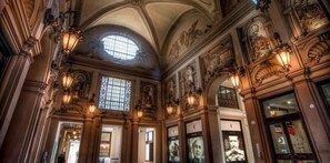 An ornate interior with high ceilings, decorative lighting, and a large arched window. - Sphera bologna (Bologna)