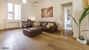 Una sala de estar con un sofá de cuero marrón, una mesa de centro de madera y una obra de arte con un mapa en la pared.