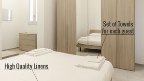 A hotel room with high-quality linens, a set of towels for each guest, and a wardrobe. - S.Felice apartments (Bologna)