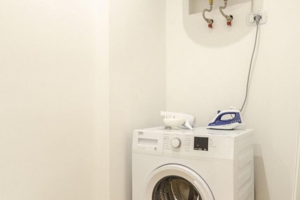 A compact, white washing machine with a control panel and a built-in dryer.
