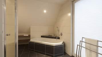 Ein modernes Badezimmer mit einer freistehenden Badewanne, einer Duschkabine aus Glas und einem Handtuchhalter.