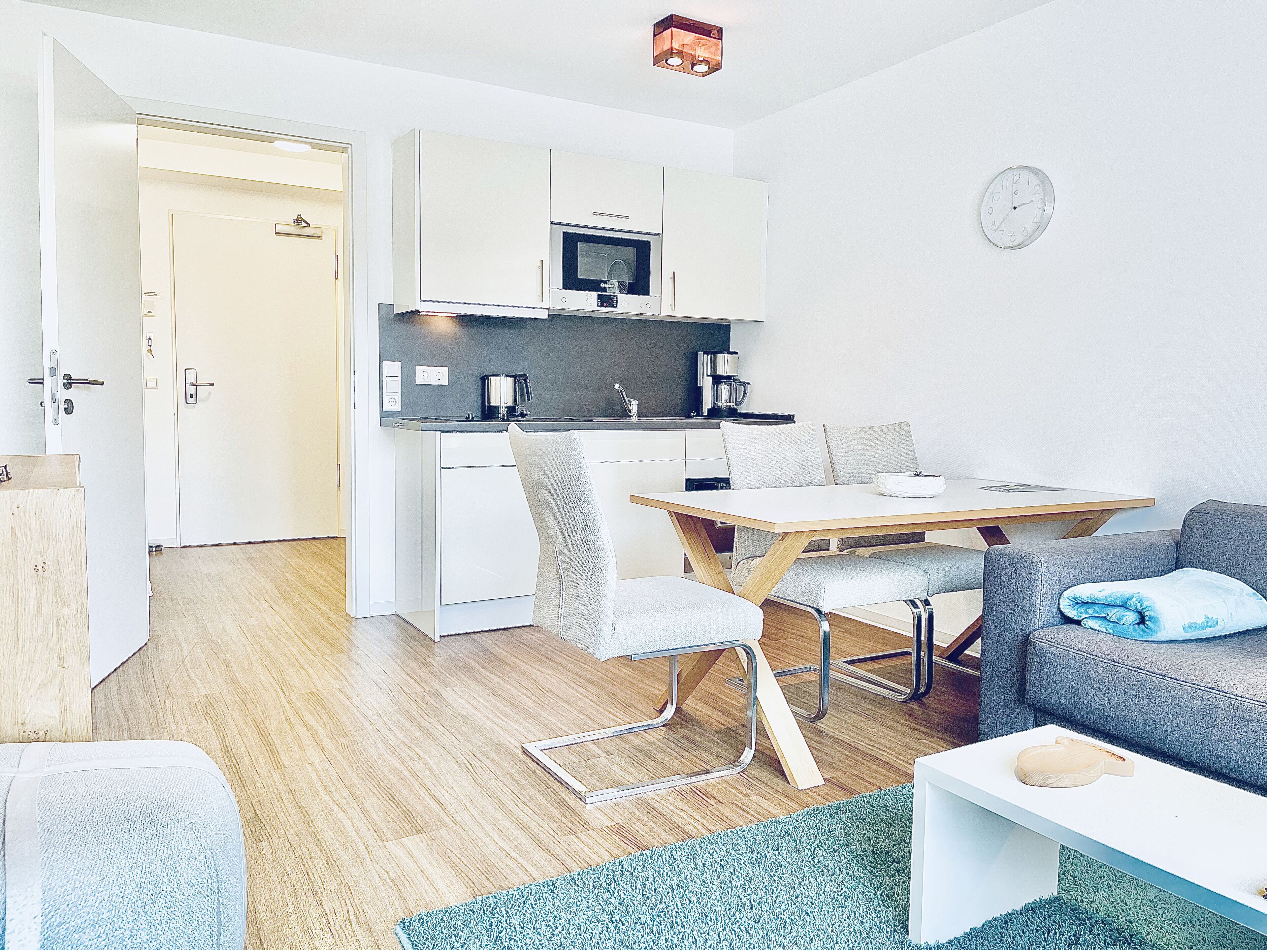 A compact living space with a kitchenette, a dining area, and a seating area.