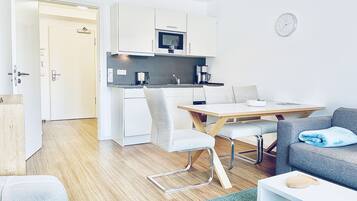 A compact living space with a kitchenette, a dining area, and a seating area.