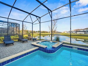 En swimmingpool med jacuzzi, liggestole og udsigt til en golfbane.