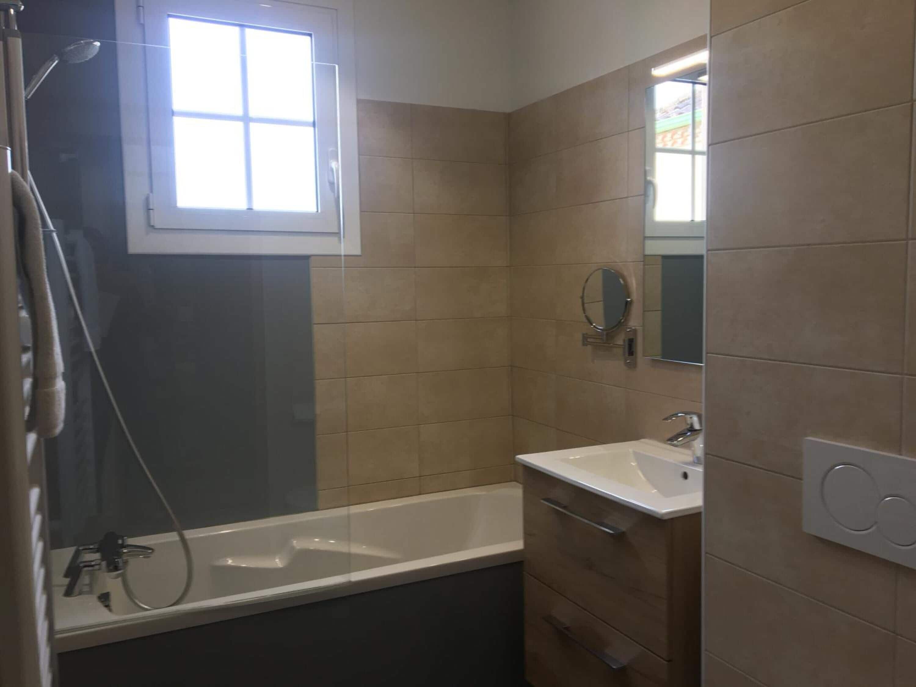 Un baño con bañera, lavabo y espejo.